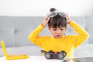 Little girls having fun in a workshop coding robot car photo