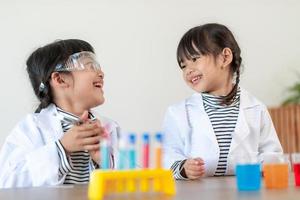 concepto de educación, ciencia, química y niños - niños o estudiantes con tubos de ensayo haciendo experimentos en el laboratorio escolar foto