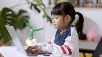 renewable energy, science, and technology concept - happy children with laptop computers, wind energy hologram,s and wind turbine models and icons. photo