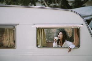 morning, coziness, winter and people concept - close up of happy young woman with cup of coffee or cocoa drink in bed photo