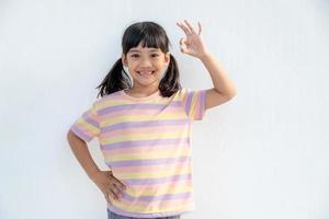 Portrait of a cute little girl kid showing okay gesture photo