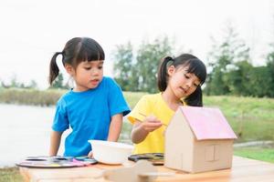 Asian sibling children drawing and painting colouring on the paper photo