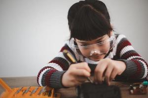 los estudiantes de asia aprenden en casa a codificar autos robot y cables de tableros electrónicos en tallo, vapor, ingeniería matemática, ciencia, tecnología, código de computadora en robótica para el concepto de niños. foto