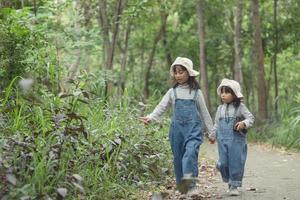 los niños se dirigen al campamento familiar en el paseo por el bosque a lo largo de la ruta turística. camino de acampada concepto de vacaciones de viaje familiar. foto