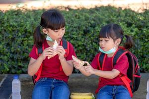 Kids eating outdoors at the school. Healthy school breakfast for children. Sandwich time. photo