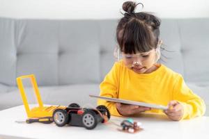 Asia students learn at home in coding robot cars and electronic board cables in STEM, STEAM, mathematics engineering science technology computer code in robotics for kids concept. photo