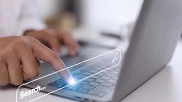 People hand using laptop or computor searching for information in internet online society web with search box icon and copyspace. photo