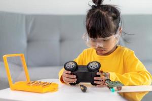 Little girls having fun in a workshop coding robot car photo
