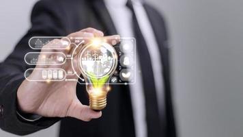 Businesswoman hand holding light bulb with esg icon on virtual screen, ESG Environmental, social and corporate governance concept photo
