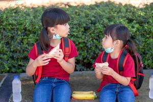 niños comiendo al aire libre en la escuela. Desayuno escolar saludable para niños. tiempo de sándwich. foto