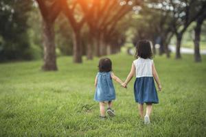 Two little sisters holding each other hands and running forward.Vintage color photo