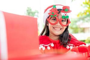Asian little girl in red Santa hat on white background. photo