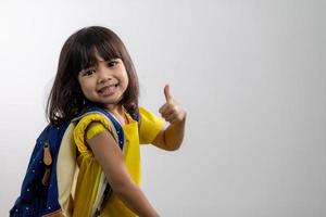 Asian young girl showing her arm with yellow bandage after got vaccinated or inoculation, child immunization, covid delta vaccine concept photo