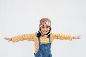 A little child girl in an astronaut costume is playing and dreaming of becoming a spaceman. on white background photo