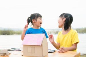 Asian sibling children drawing and painting colouring on the paper photo