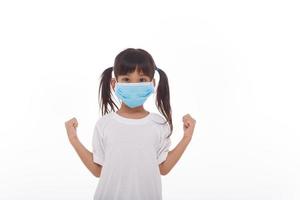 asia girl wearing mask to protect against Coronavirus, girl show a fist encourage to fight contagious disease concept stop virus Covid 19 outbreak to win on white background