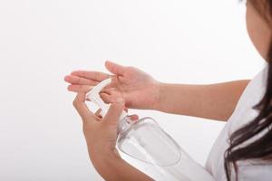 Cute Asian girl wearing a mask and washing her hands with alcohol to prevent spreading the disease on a white background. Prevention of the spread of influenza virus Coronary COVID-19 influenza photo