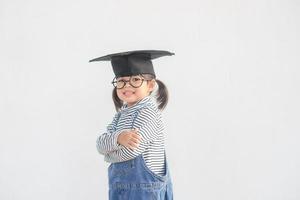 Happy Asian school kid graduate in graduation cap photo