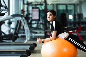 Photo of beautiful young sporty woman. Girl working out with fitness ball