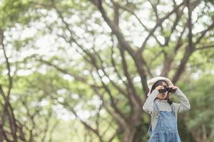 Happy kid looking ahead. Smiling child with the binoculars. Travel and adventure concept. Freedom, vacation photo