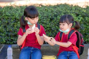 Kids eating outdoors at the school. Healthy school breakfast for children. Sandwich time. photo