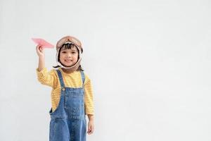 una linda niña vestida con una gorra y gafas de piloto. el niño sueña con convertirse en piloto. foto