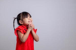 happy Chinese new year. Little Asian girls with Congratulation gesture photo