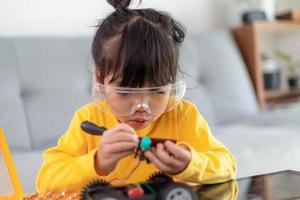 Little girls having fun in a workshop coding robot car photo