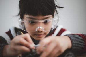 Asia students learn at home in coding robot cars and electronic board cables in STEM, STEAM, mathematics engineering science technology computer code in robotics for kids concept. photo