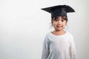 feliz niño de la escuela asiática graduado en gorra de graduación foto