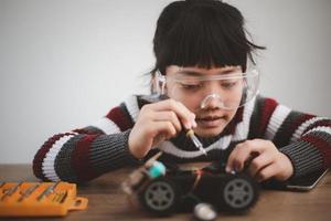 Little girls having fun in a workshop coding robot car photo