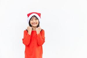 Asian little girl in red Santa hat on white background. photo