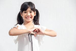 Little girl hands making a heart shape on white background photo