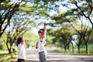 Two asian little girls having fun and running together in the park in vintage color tone photo