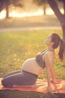 healthy pregnant woman doing yoga in nature outdoors.Vintage color photo