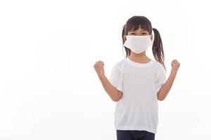 asia girl wearing mask to protect against Coronavirus, girl show a fist encourage to fight contagious disease concept stop virus Covid 19 outbreak to win on white background