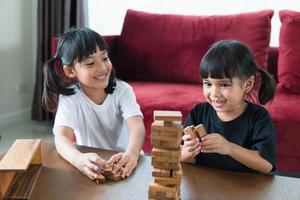 two Asian girl playing wooden stacks at home photo