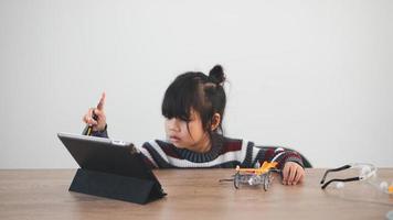 Inventive kid constructing robot cars at home photo