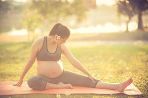 healthy pregnant woman doing yoga in nature outdoors.Vintage color photo