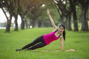 Young woman practicing yoga in park photo