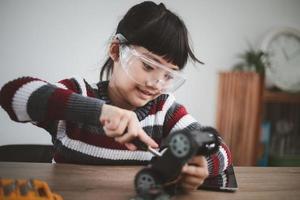 Little girls having fun in a workshop coding robot car photo
