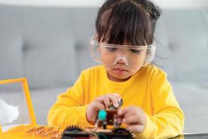 Little girls having fun in a workshop coding robot car photo