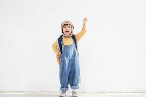 una linda niña vestida con una gorra y gafas de piloto. el niño sueña con convertirse en piloto. foto