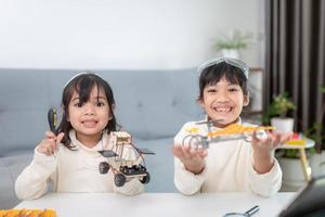 Inventive kid constructing robot cars at home photo