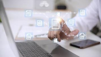 Businessman working with electronics document icons, E-document management, online documentation database, paperless office concept photo