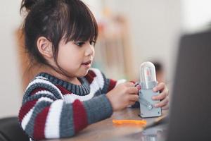 Inventive kid constructing robot cars at home photo