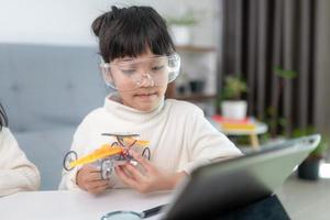 Inventive kid constructing robot cars at home photo
