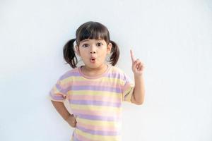 Asian student girl over white background pointing finger up with a successful idea. Excited and happy. Number one. photo