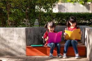 two beautiful little girls reading books in the garden. The concept of education photo