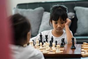 Two cute children playing chess at home photo